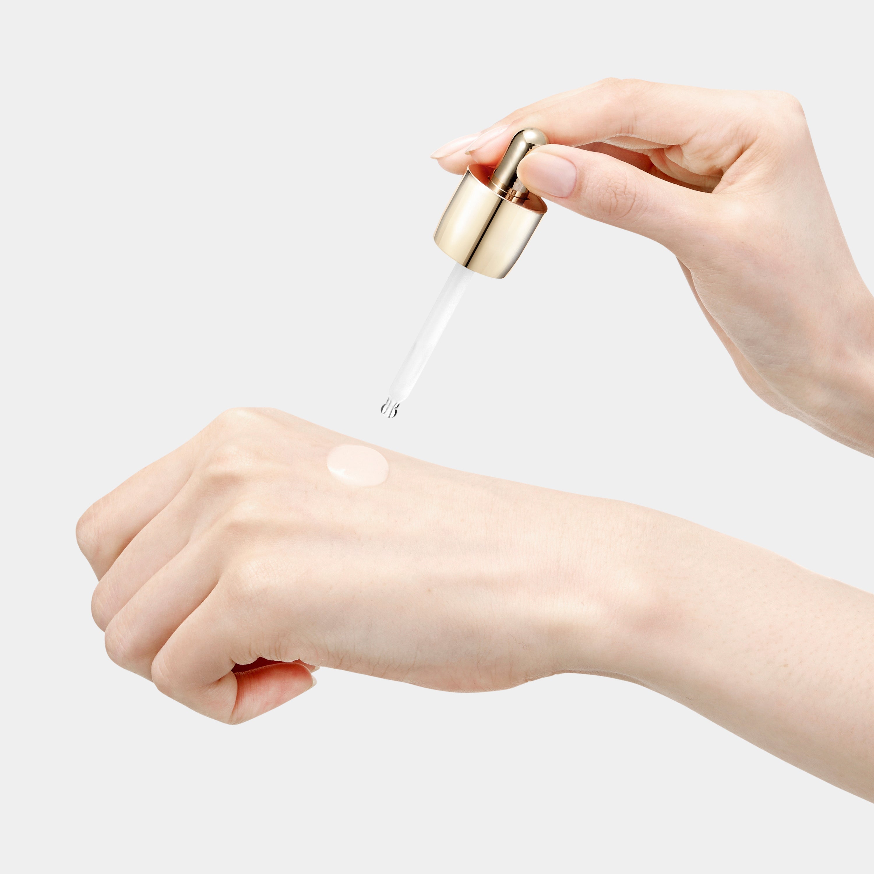 A hand gently applies the Sulwhasoo Concentrated Ginseng Brightening Spot Ampoule to skin, showcasing the ampoule's lightweight texture and its potential to improve dullness and dark spots for a radiant complexion.