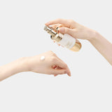 A hand dispenses Sulwhasoo's Concentrated Ginseng Brightening Serum onto another hand, showcasing the serum's creamy texture and highlighting its radiance-boosting properties for improved skin elasticity.